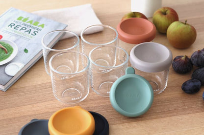 Zdjęcie poglądowe Béaba Glass Portions Sunrise – pojemniki na stole obok owoców