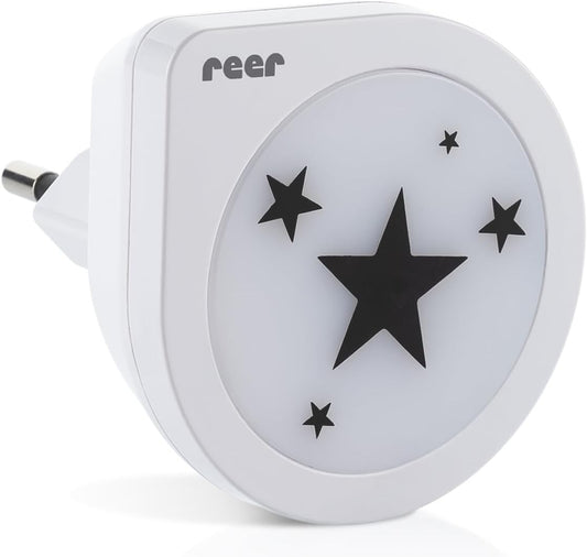Biała lampka Reer NightGuide Star z czarnymi gwiazdkami i wtyczką, widok pod kątem.